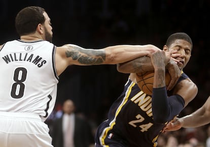 Paul George, de los Pacers, protege el balón ante Deron Williams.