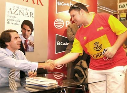 El ex presidente José María Aznar saluda a un lector ataviado con una camiseta de la selección española, ayer en A Coruña.