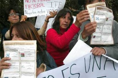Simpatizantes del candidato a la presidencia de México por la coalición 'Por el bien de todos', Andrés Manuel López Obrador, sostienen boletas electorales que encontraron en un vertedero de basura.