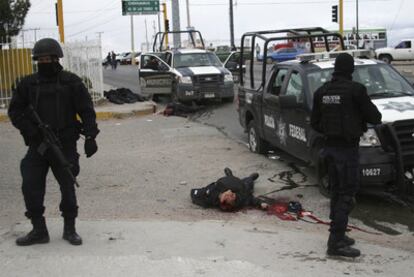 Varios policias custodian los cuerpos de sus colegas asesinados por los 'narcos'.