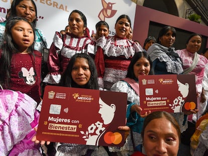 Mujeres muestran tarjetas a gran escala del plástico del programa 'Mujeres con bienestar', en Toluca, el 20 de noviembre.