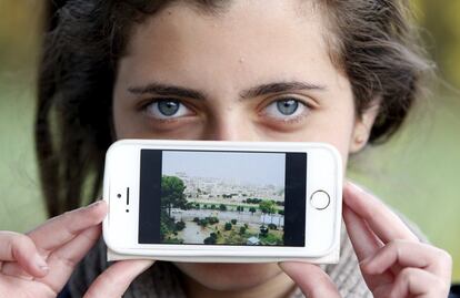 Haya procede de Artoz (Siria), el pueblo fotografiado en su móvil. Como el resto de refugiados de esta galería, Haya esperaba este domingo a cruzar la frontera entre Eslovenia y Austria.