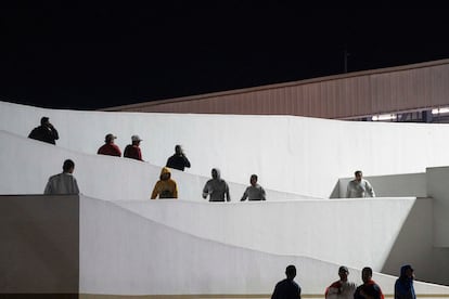 Migrantes cruzan hacia México desde Estados Unidos tras su deportación en el puente fronterizo El Chaparral, en Tijuana, Baja California.