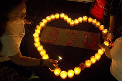 Familiares de los pasajeros del vuelo desaparecido de Malaysia Airlines encienden unas velas en Pekín (China).