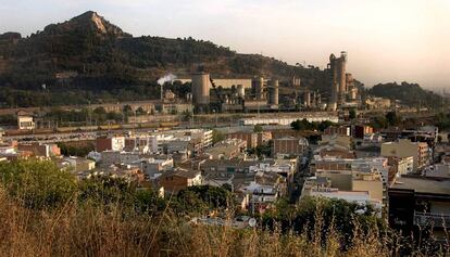 Un barrio de casas con la cementera de Montcada al fondo.
