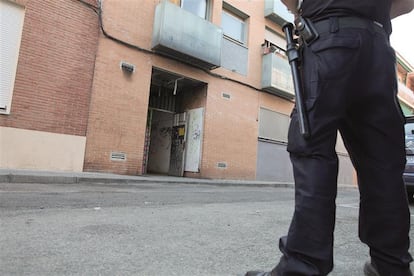 Un policía nacional vigila la entrada de un edificio okupa en el distrito madrileño de Carabanchel, 2021.