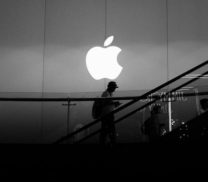 Logo de Apple en unas escaleras y encima de una persona utilizando un iPhone