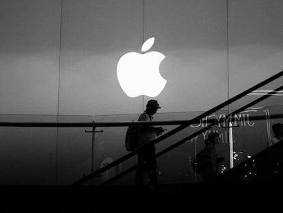 Logo de Apple en unas escaleras y encima de una persona utilizando un iPhone