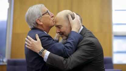 El presidente de la Comisión Europea, Jean-Claude Juncker, besa en la frente al comisario europeo de Asuntos Económicos, Pierre Moscovici.