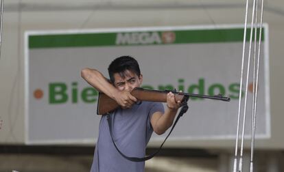 Un empleado de un supermercado de Los Cabos apunta con un rifle para impedir el saqueo del establecimiento.