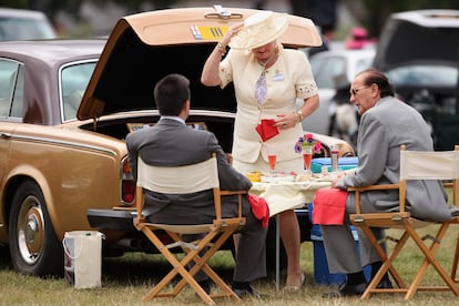 Asistentes a Ascot toman un picnic, salido del maletero de su Rolls Royce, una tradición en este evento que cumple ya 300 años.