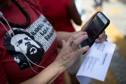 Una mujer seguidora de Lula Da Silva usa su teléfono celular durante una protesta en apoyo del expresidente.