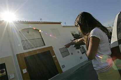 Una mujer señala la casa donde el hombre mató a su mujer y su hija.