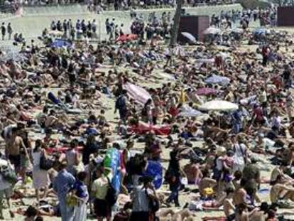 Playa de Barcelona abarrotada de gente. PLANO GENERAL - ESCENA