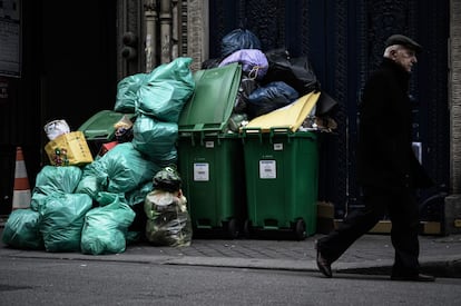 Un hombre camina junto a la basura acumulada en las calles de París, el 5 de febrero, tras el bloqueo de incineradores alrededor de la capital francesa para protestar contra la reforma de las pensiones.