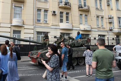 Civilians in the Russian city of Rostov walk past a tank with members of the Wagner group.