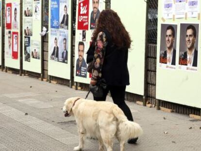 Una mujer pasa por delante de carteles en Santurtzi (Bizkaia).
