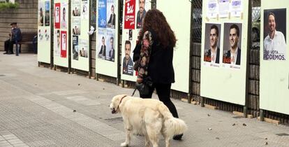 Una mujer pasa por delante de carteles en Santurtzi (Bizkaia).