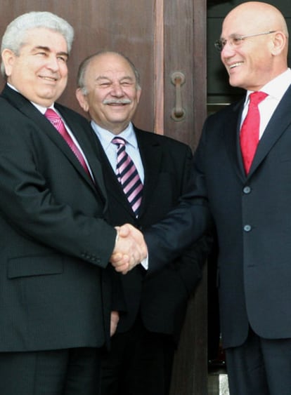 Demetris Christofias, presidente greco chipriota, estrecha la mano de su homólogo turcochipriota Mehmet Ali Talat a su llegada a la residencia oficial del emviado de la ONU Michelle Moller