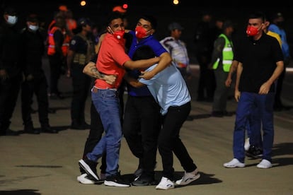 Hombres se abrazan tras desembarcar del avión que transportaba venezolanos detenidos en El Salvador, a su llegada al Aeropuerto Internacional Simón Bolívar en Maiquetía, Venezuela.