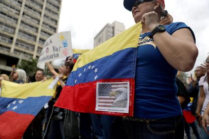 Una manifestante porta una bandera con un pegatina del águila americana, signo de los EE UU.