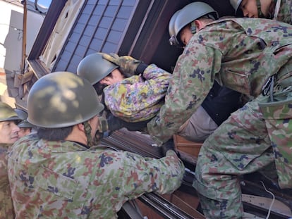Un grupo de militares rescatan a una persona entre los escombros de una vivienda este martes en Wajima. 