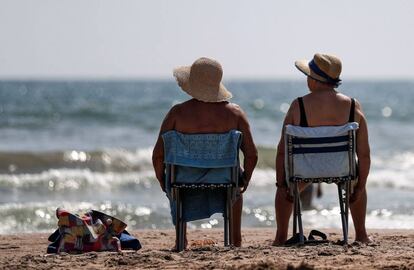 Dos mujeres toman el sol en la playa de La Malvarrosa de Valéncia.