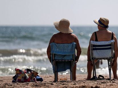 Dos mujeres toman el sol en la playa de La Malvarrosa de Valéncia.