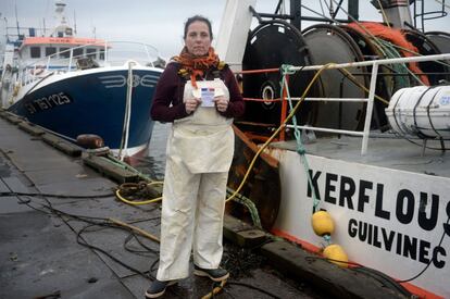 Marie Rouffet, 47, a fisherwoman currently training to be a mechanic, mother of 4, poses with her voting card on February 7, 2017 at the port of Le Guilvinec, northwest France.
What should be the priorities of the next French president?
"I don't have any expectations any more. We just go from disappointment to disappointment. Doesn't matter if they are from the right-wing, the left-wing, the centre, sideways, up, down, it's rotten to the core and the higher up the chain of power you go, the more corrupt you are and the more money you're siphoning off. What's more, the people that spit out our laws don't know the first thing about boats or fish. They've probably never been to sea. So the presidential election campaign doesn't interest me. Like all my fishing colleagues, we're just interested in fishing campaigns. Doesn't matter to me who's president, nothing will stop me fishing in an industry that still has a future." / AFP PHOTO / FRED TANNEAU / RESTRICTED TO EDITORIAL USE - RESTRICTED TO FRENCH ELECTIONS ILLUSTRATION PURPOSE