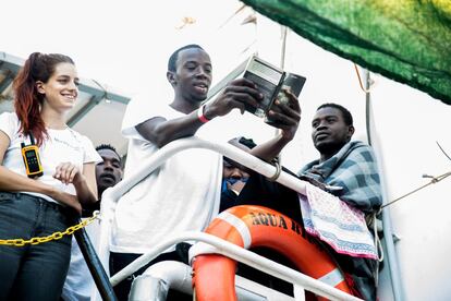 Un migrante lee en voz alta un libro que trajo con él titulado '1000 Personas positivas'.