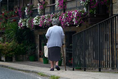 Una mujer pasea por Villacarriedo, pueblo de los valles pasiegos de Cantabria.