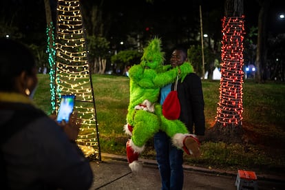 Un hombre disfrazado posa para una foto con uno de los visitantes del parque durante la noche del 16 de diciembre.