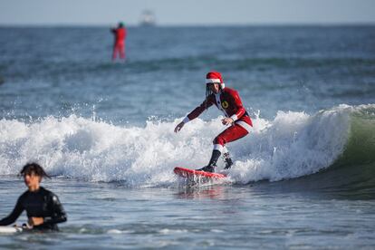 Un surfista con neopreno de Papá Noel navega una ola en Cocoa Beach, Florida, EE UU, el 24 de diciembre.