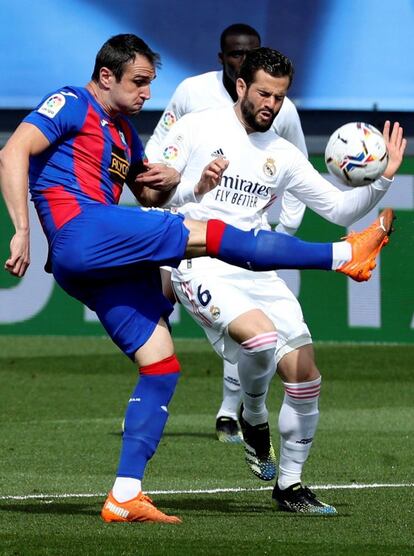 El defensa del Real Madrid Nacho lucha por el balón con el delantero del Eibar Kike García.