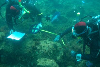 Dos submarinistas realizan mediciones en zonas arqueológicas sumergidas en la bahía de Cádiz.