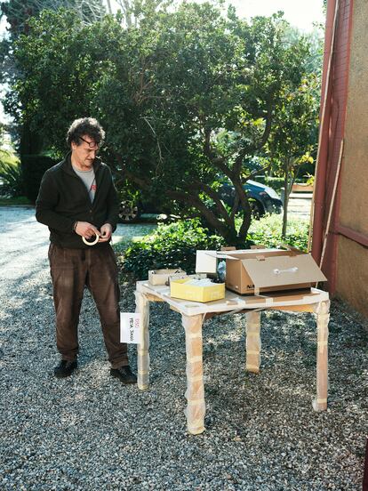 Gonzalo Milá, hijo del diseñador, embala una mesa para la exposición.