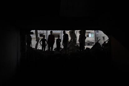 Palestinos inspeccionan los daños de una casa destruida por los bombardeos israelíes de la madrugada de este lunes.