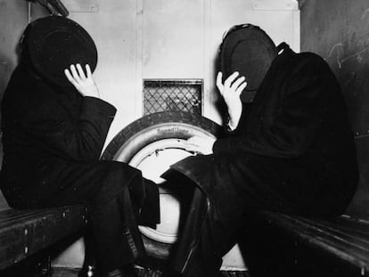 Dos delinq&uuml;ents es cobreixen amb els seus barrets del fot&ograve;graf el 1942.