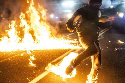 Un manifestante es alcanzado por las llamas de un cóctel molotov durante las protestas en Portland (EE UU). Varias decenas de personas fueron detenidas el sábado por la noche en la ciudad, en una nueva jornada de movilizaciones para protestar contra la discriminación racial y la brutalidad policial.