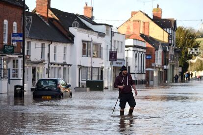 Un hombre cruza una calle inundada de Tenbury Wells, junto al río Teme, en el centro de Inglaterra.