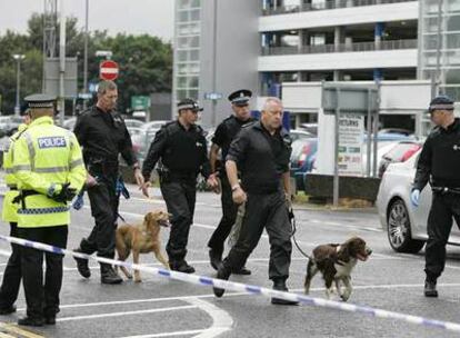 Agentes de policía llegan al aeropuerto de Glasgow, después de que un <i>jeep</i> en llamas se estrellara contra la terminal.