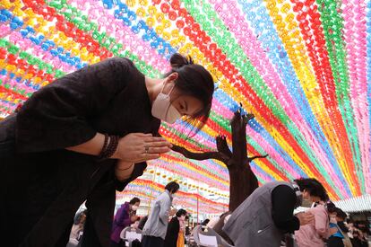 Creyentes protegidos con mascarillas conmemoran en un templo de Seúl el cumpleaños de Buda.