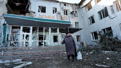 Una mujer junto a un hospital destruido en la ciudad de Volnovakha, Ucrania.