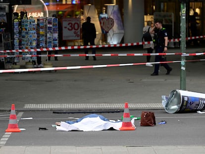 The body of a dead person is seen at a cordoned-off area at the site where a car ploughed into a crowd near Tauentzienstrasse in central Berlin, on June 8, 2022. - One person was killed and eight injured when a car drove into a group of people in central Berlin on June 8, the fire service said. A police spokeswoman said the driver was detained at the scene after the car ploughed into a shop front along busy shopping street Tauentzienstrasse. It was not clear whether the crash was intentional. (Photo by John MACDOUGALL / AFP)