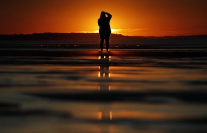 Una mujer fotografía el amanecer en Ocean Park, en el estado de Maine (EE UU), el 12 de julio de 2018.