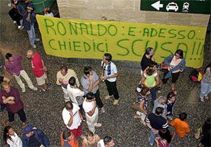 Aficionados del Inter, ante un cartel en el que puede leerse: 'Ronaldo: y ahora... ¡pide perdón!', ayer en el aeropuerto de Malpensa.