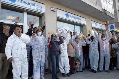 Un grupo de manifestantes protesta ante una sucursal de Novagalicia Banco en A Illa de Arousa.