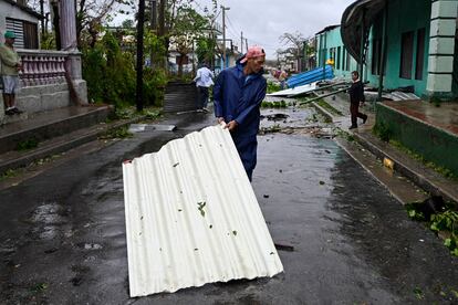 Un hombre mueve un trozo de techo en una calle de Consolación del Sur (Cuba), este martes, tras el paso del huracán.