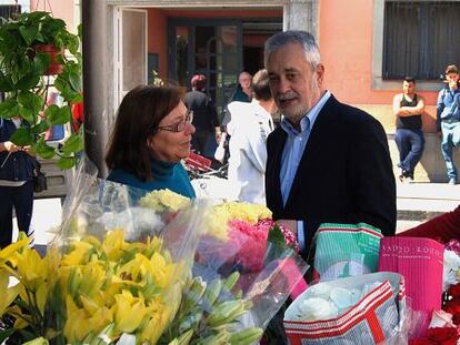 Griñán conversa en Motril (Granada) con una mujer en un puesto de flores.