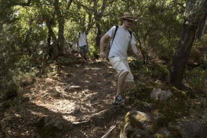 Dos senderistas recorren la ruta de la Garganta de Puerto Oscuro, en el parque natural de los Alcornocales.